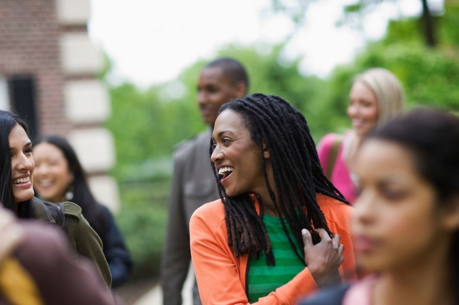 A group of people talking and laughing together outdoors